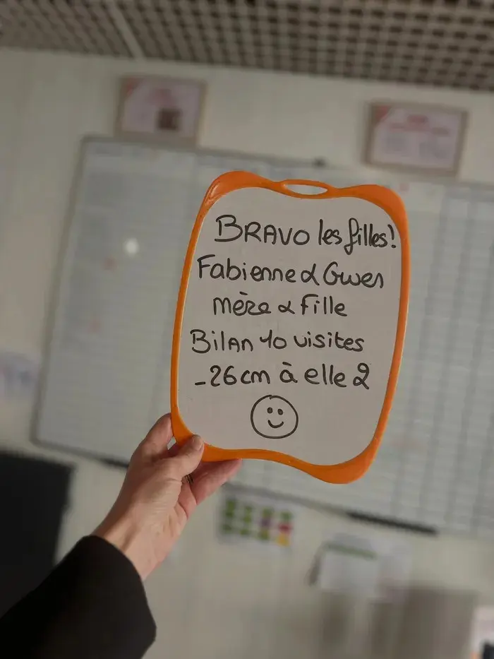 Fabienne & Gwen avec son ardoise : Mère et fille, bilan des 10 visites : −26 cm à elles deux.