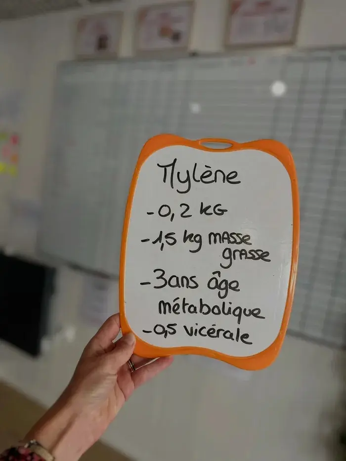 Mylène avec son ardoise : −1,5 kg de masse grasse, −3 ans d'âge métabolique.