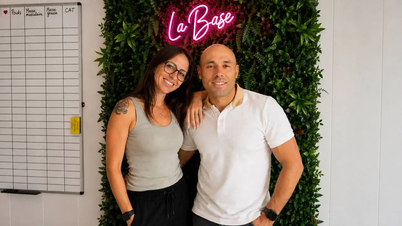 Mélanie et Thomas au club, devant le mur végétal et l'enseigne lumineuse La Base.
